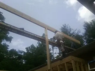 Carpenter setting a ridge beam over a new addition frame — Ice Dam Removal by Roofing Brothers in Hardeeville